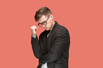 Image showing Young handsome man in black suit and glasses isolated on red background