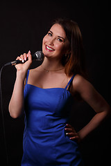 Image showing Beautiful singing girl holds microphone