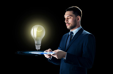 Image showing businessman with tablet pc and lightbulb