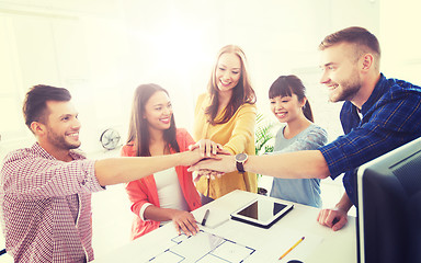 Image showing creative team holding hands together  at office