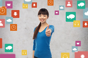 Image showing happy smiling young woman showing thumbs up