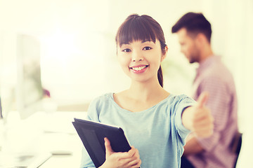 Image showing happy creative female office worker with tablet pc