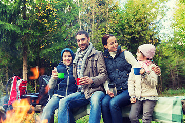 Image showing happy family sitting on bench at camp fire