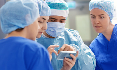 Image showing group of surgeons with smartphone at hospital