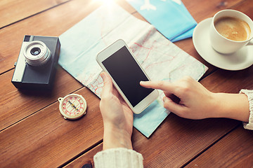 Image showing close up of traveler hands with smartphone and map