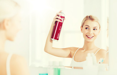 Image showing woman with hairspray styling her hair at bathroom