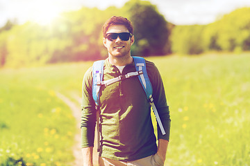 Image showing happy young man with backpack hiking outdoors