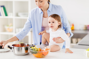 Image showing happy mother and baby cooking vegetables at home
