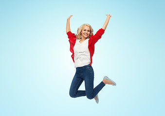 Image showing smiling young woman jumping in air