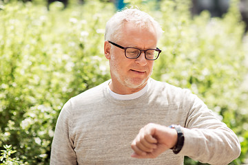 Image showing senior man checking time on his wristwatch