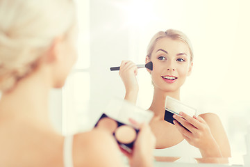 Image showing woman with makeup brush and foundation at bathroom