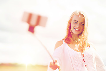 Image showing happy young woman taking selfie by smartphone