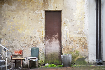 Image showing Pot for flowers, two chairs near abandoned grunge cracked wall