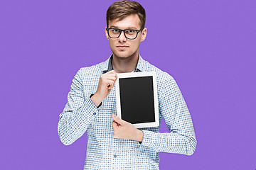 Image showing The young man in a shirt working on laptop on lilac backgroundin