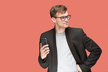 Image showing The young caucasian businessman on red background talking on cell phone