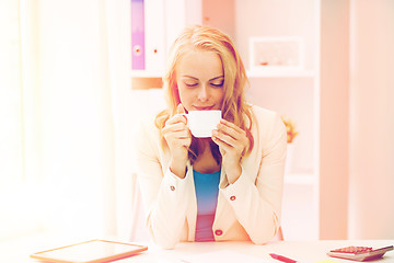 Image showing happy businesswoman drinking coffee at office