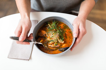 Image showing woman eating seafood soup at restaurant