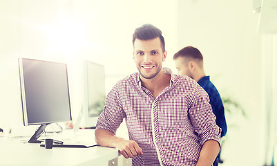 Image showing happy creative man with computer at office