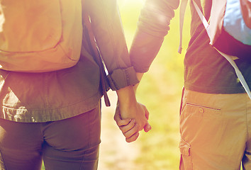 Image showing close up of couple with backpacks holding hands
