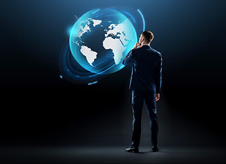 Image showing businessman looking at earth globe hologram