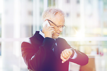 Image showing senior businessman calling on smartphone in city