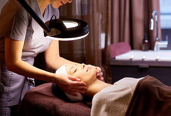 Image showing beautician doing face massage to woman at spa