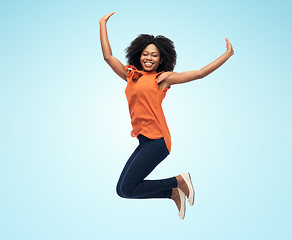 Image showing happy african american woman jumping over white