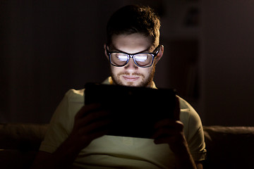 Image showing young man with tablet pc networking at night