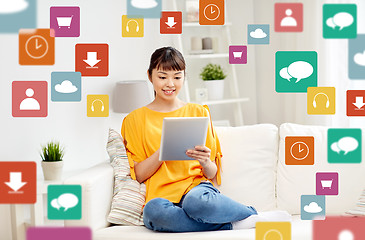 Image showing happy young asian woman with tablet pc at home