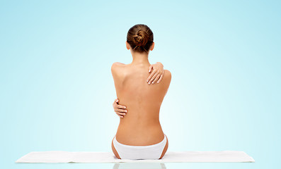 Image showing beautiful topless young woman on towel from back