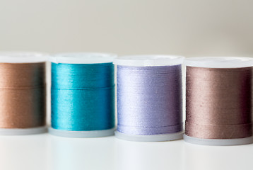 Image showing row of colorful thread spools on table