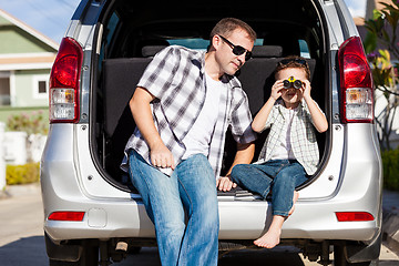 Image showing Happy father and son getting ready for road trip on a sunny day.