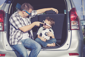 Image showing Happy father and son getting ready for road trip on a sunny day