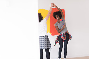 Image showing multiethnic couple painting interior wall