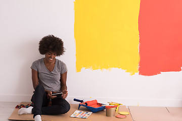 Image showing back female painter sitting on floor
