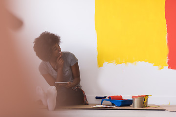 Image showing back female painter sitting on floor