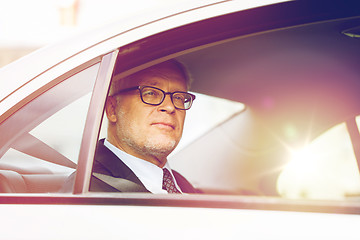 Image showing senior businessman driving on car back seat