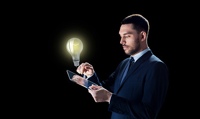 Image showing businessman with tablet pc and lightbulb