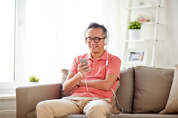 Image showing man with smartphone and headphones at home