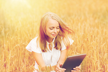 Image showing happy young woman with tablet pc on cereal field