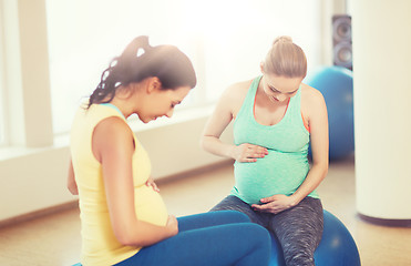 Image showing two happy pregnant women sitting on balls in gym