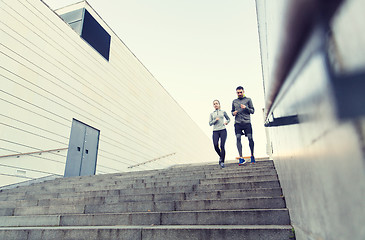 Image showing couple running downstairs on city stairs