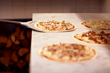 Image showing peel taking pizza off table at pizzeria