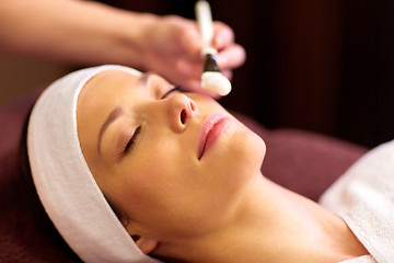 Image showing beautician applying facial mask to woman at spa