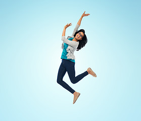 Image showing smiling young indian woman jumping in air