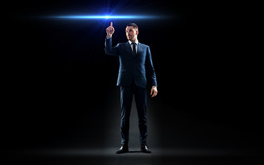 Image showing businessman in suit pointing finger to laser light