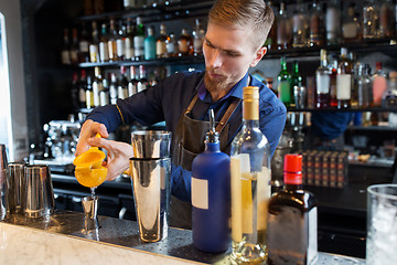 Image showing barman with shaker, alcohol and jigger at bar