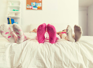 Image showing close up of women feet in socks on bed at home