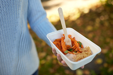 Image showing close up of hand holding plate with sweet potato