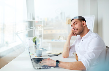 Image showing businessman with laptop thinking at office